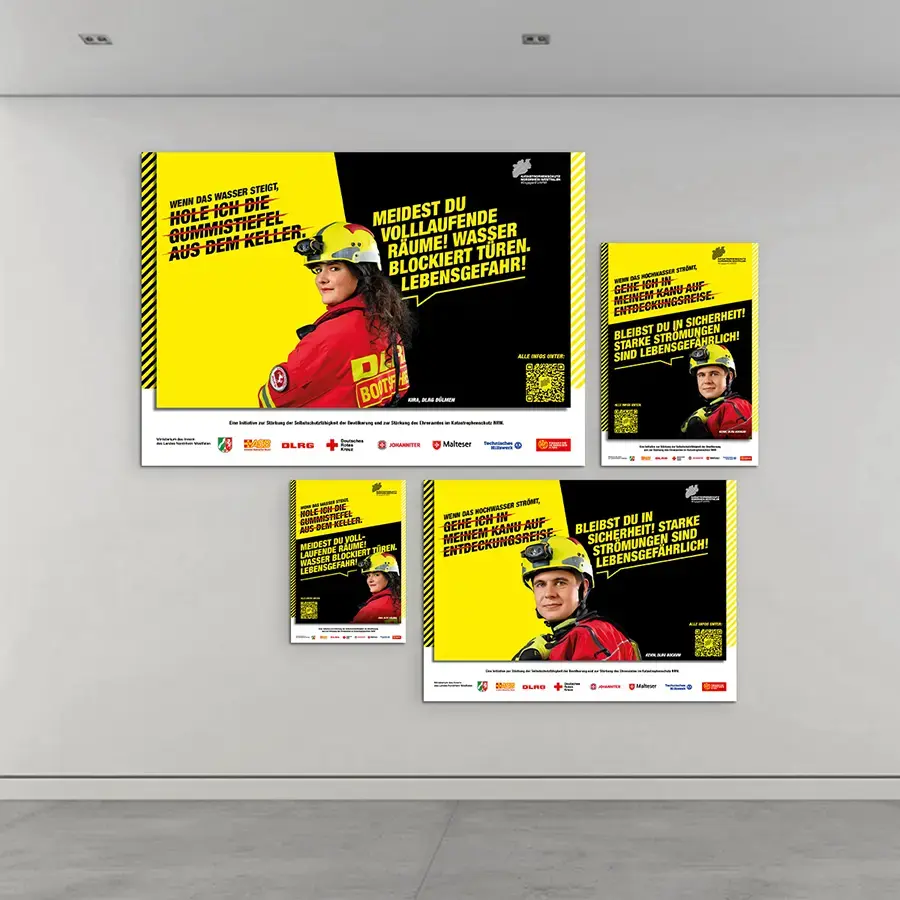 Das Bild zeigt verschiedene Plakatadaptionen der Befähigungsmotive an einer Wand.