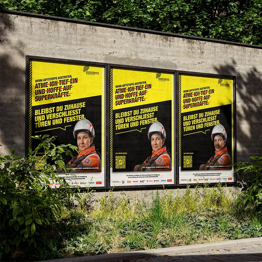 Hochformate des Befähigungsmotivs mit einer Katastrophenschützerin von der JUH an einer Mauer.