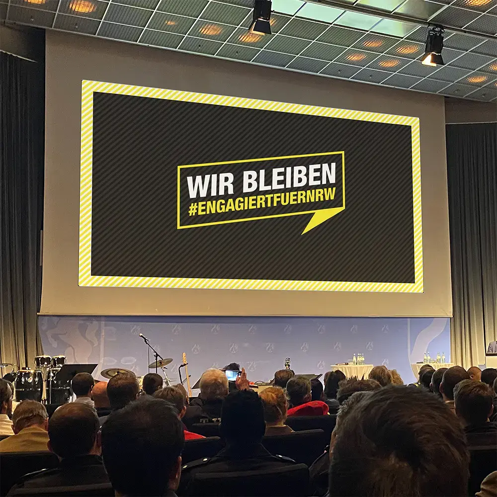 Ein Foto der Slideshow auf der Bühne beim Tag des Ehrenamtes, vom Publikum aus fotografiert.