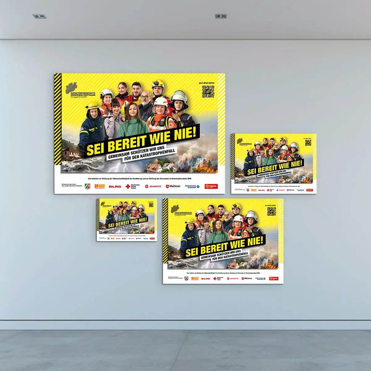 Das Bild zeigt eine Gruppe des gleichen Posters. Auf dem Poster: Eine Gruppe aus Katastrophenschützerinnen und Zivillisten stehen vor einem gelben Hintergrund. Auf den Bildern steht der Slogan &quot;SEI BEREIT WIE NIE!&quot;